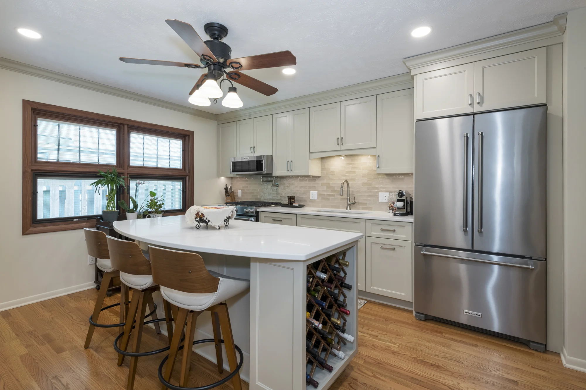 Classic tone-on-tone kitchen with a curved island and wine storage in Berea
