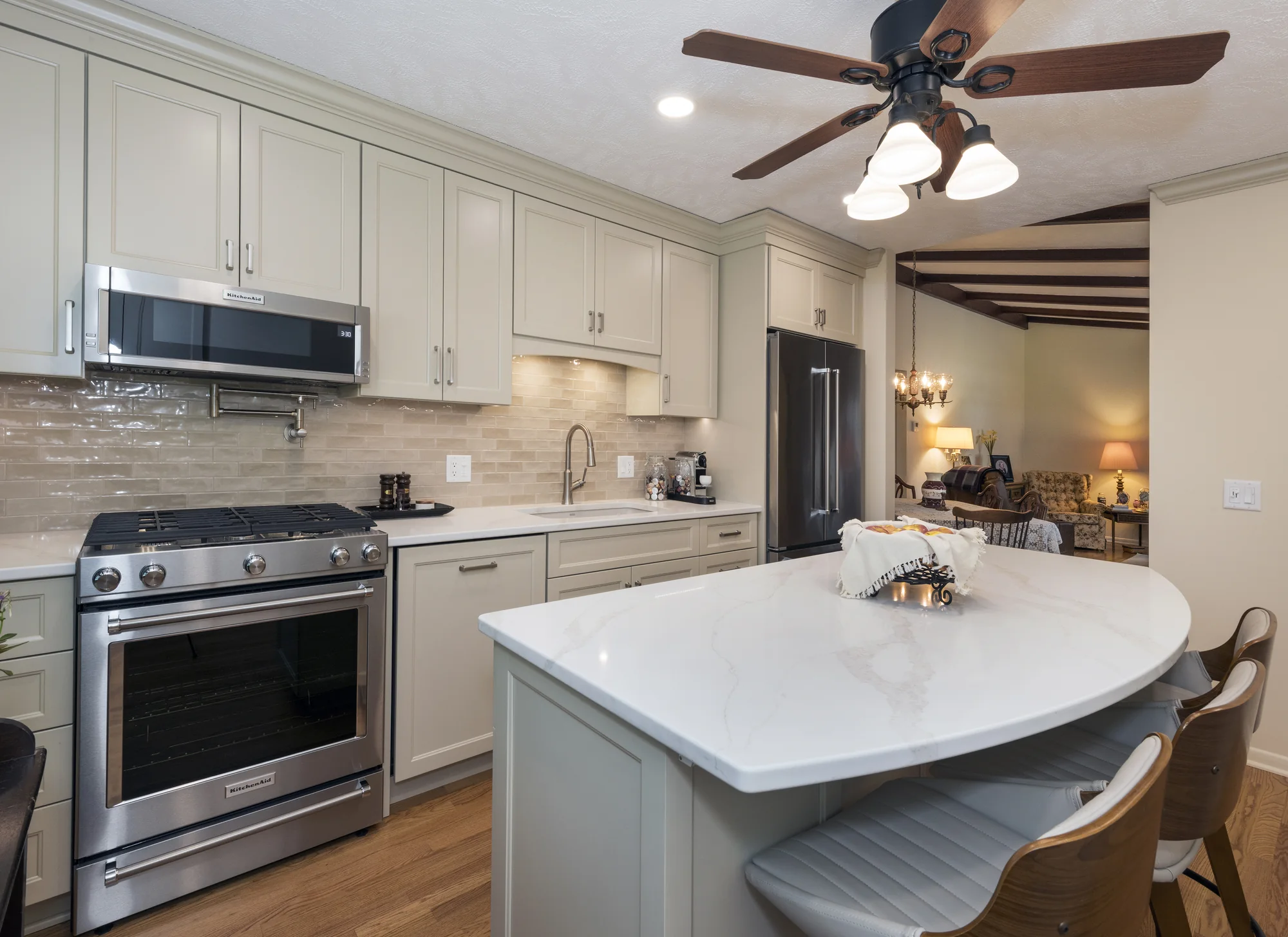 Tone-on-tone kitchen viewed across the curved island