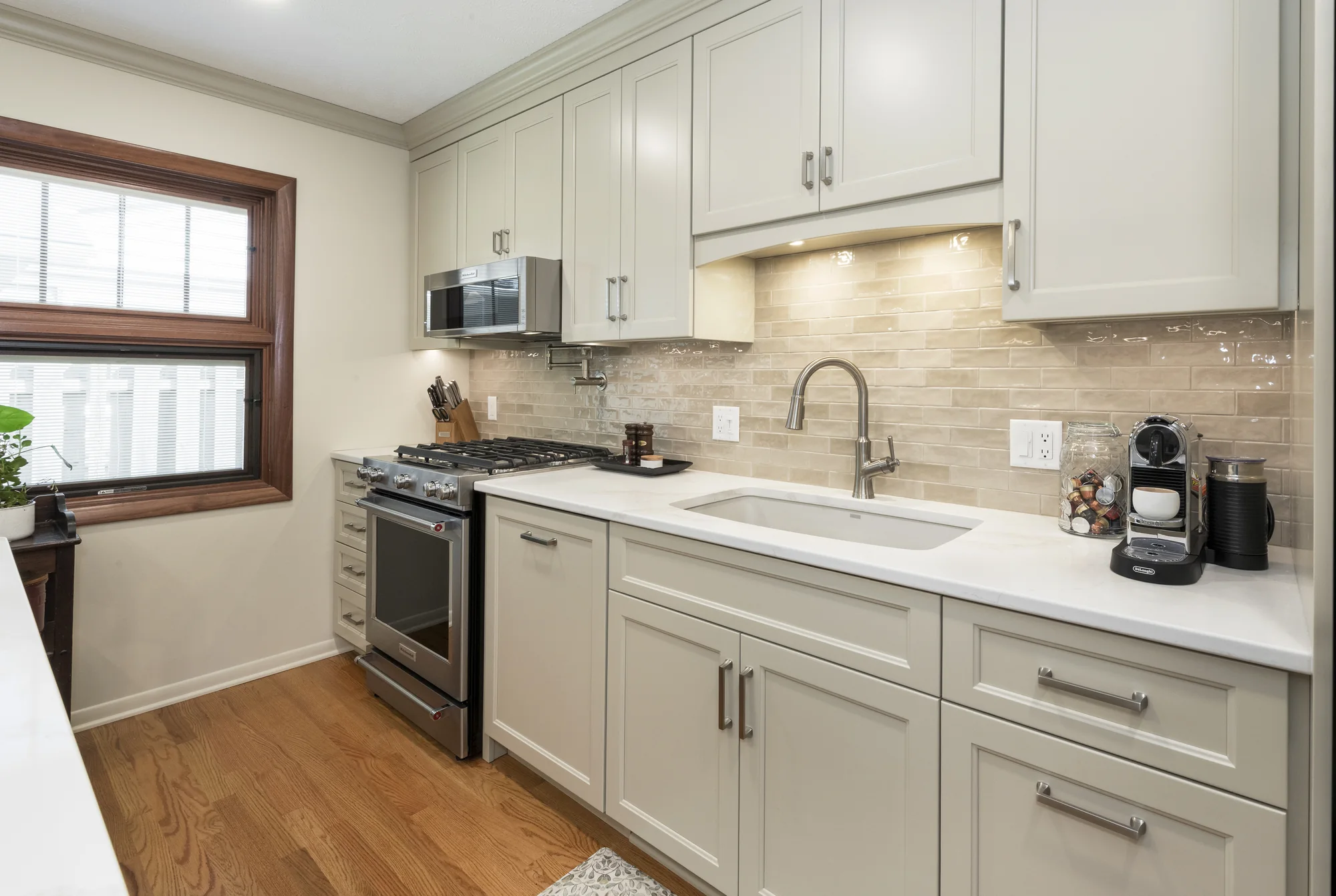 Range and sink wall with warm neutral finishes
