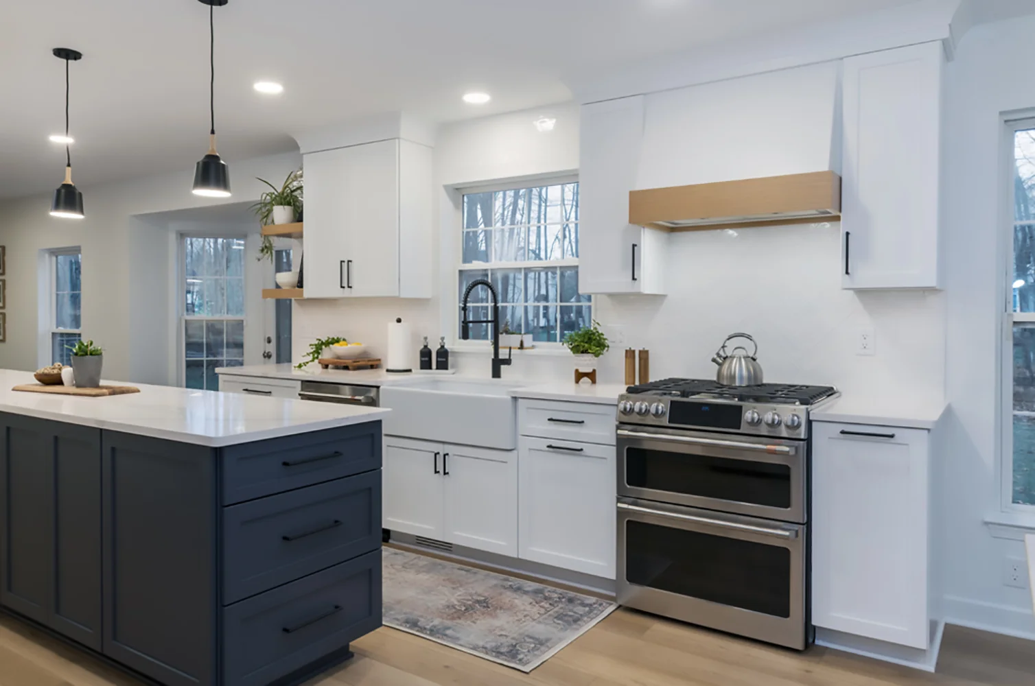 Blue island and white range wall with wood hood detail