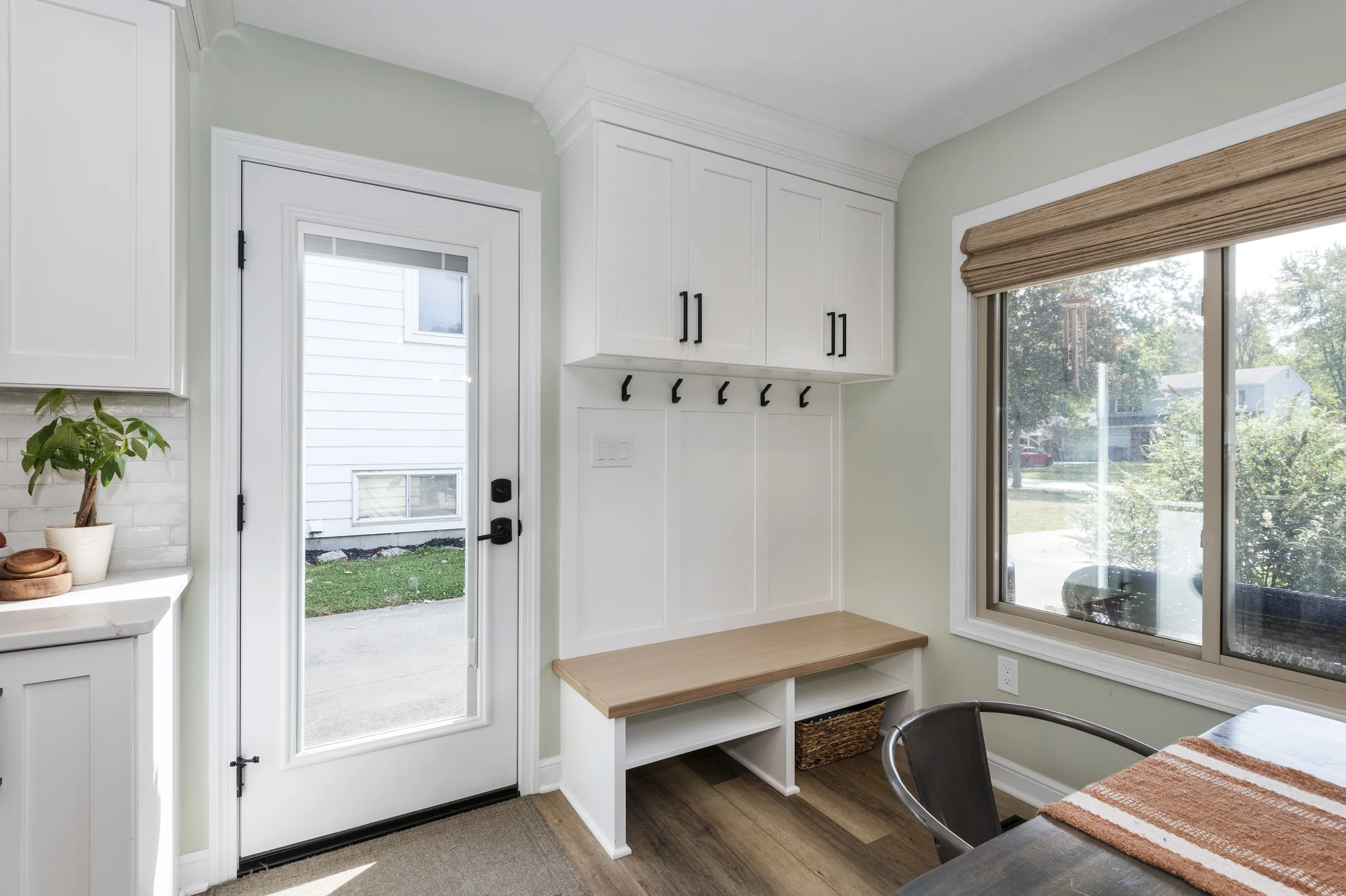 Built-in entry bench and tall white storage cabinetry