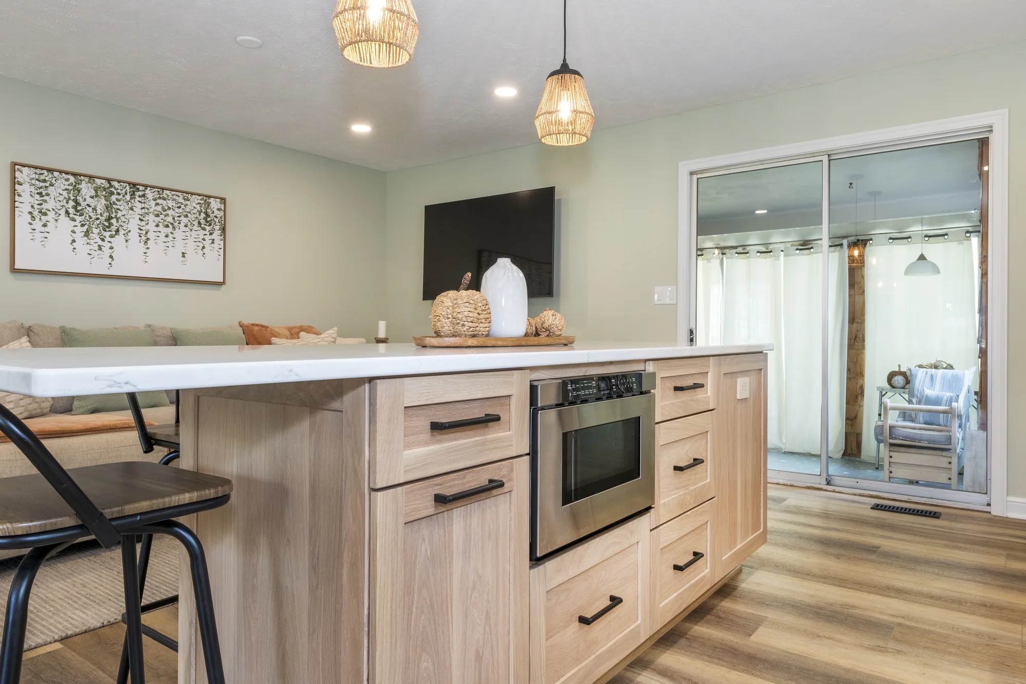 Natural wood island cabinetry with integrated appliances