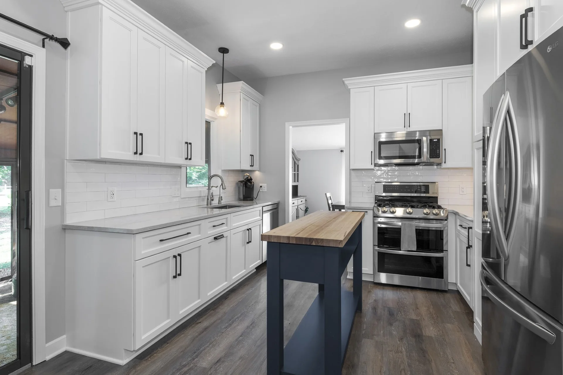 Timeless white kitchen with a dark blue worktable island in Elyria