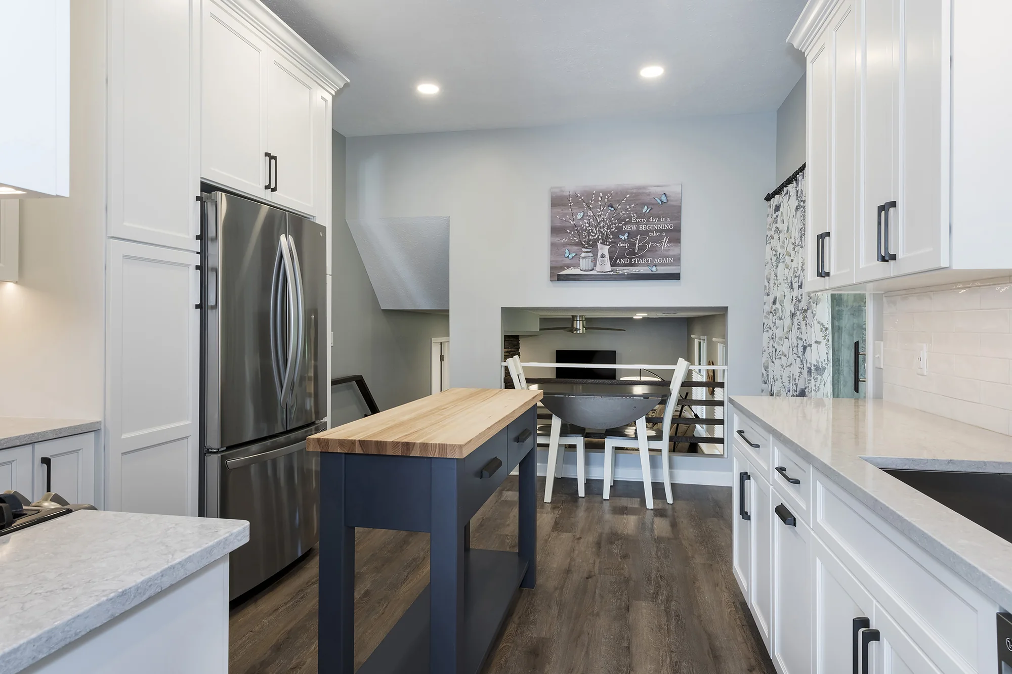 Kitchen view toward the dining nook and blue worktable island