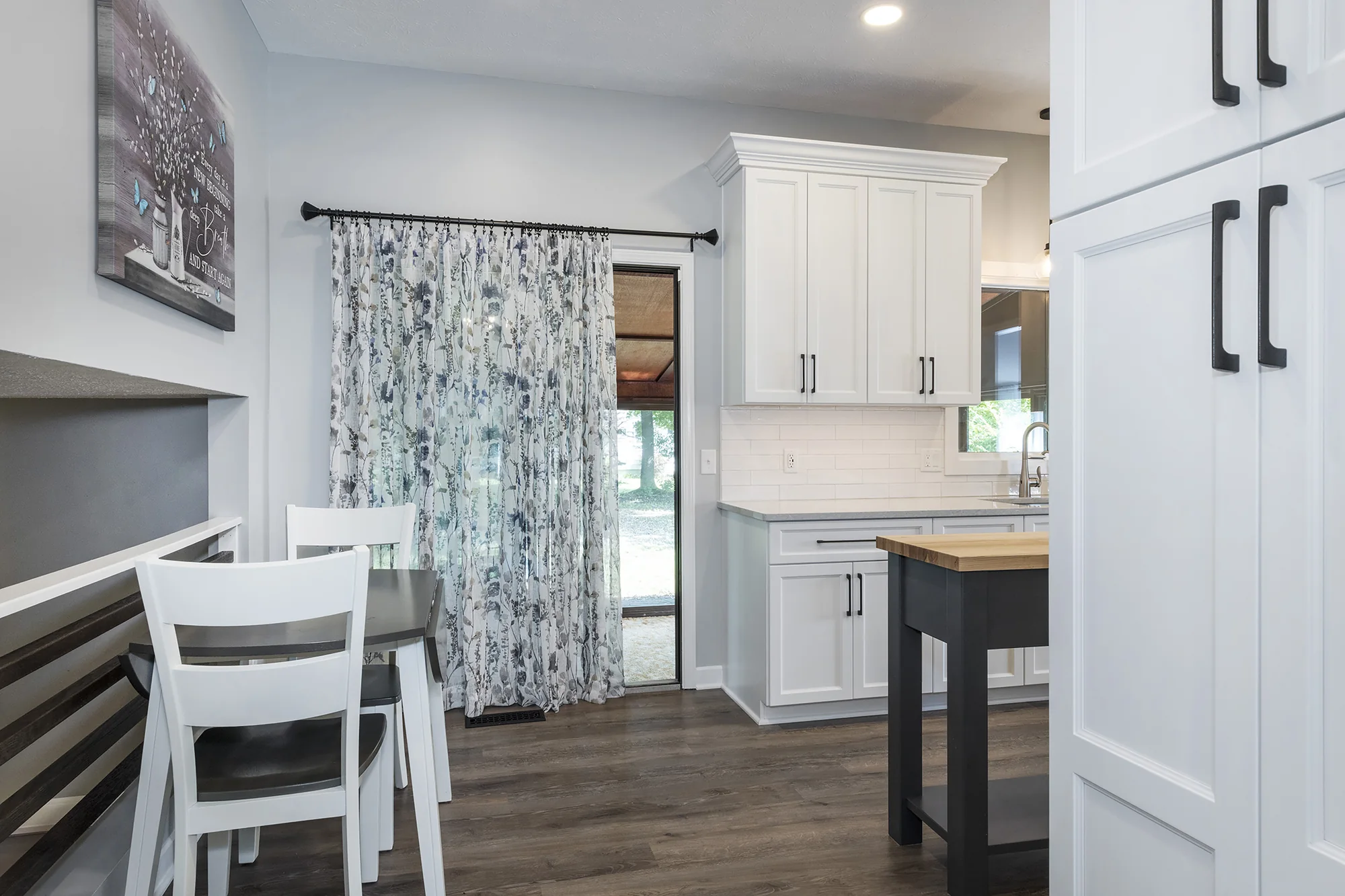 White cabinetry and dining nook beside the kitchen