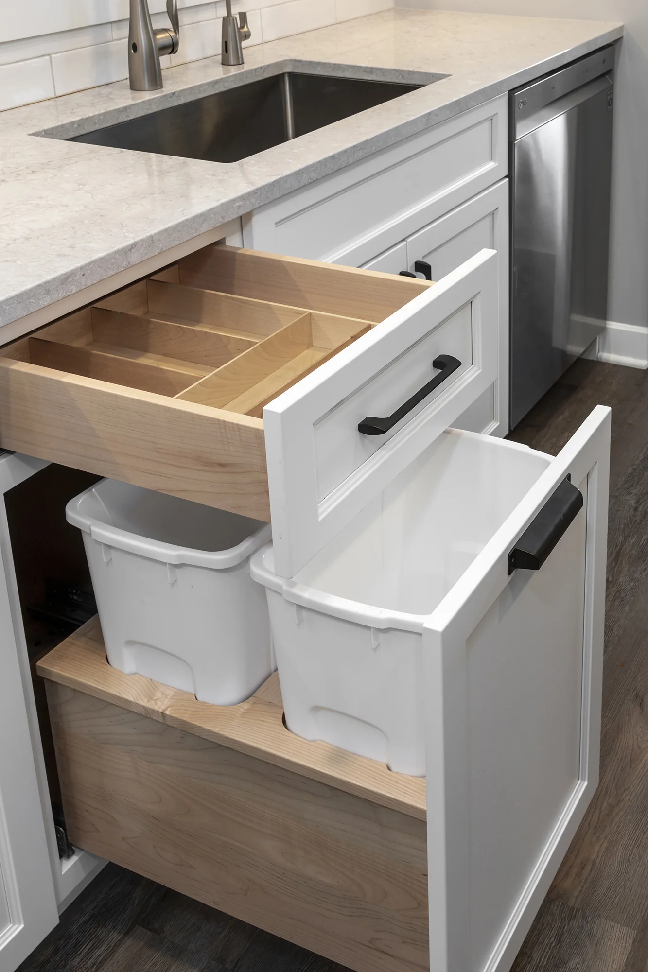 Custom utensil drawer above organized waste storage