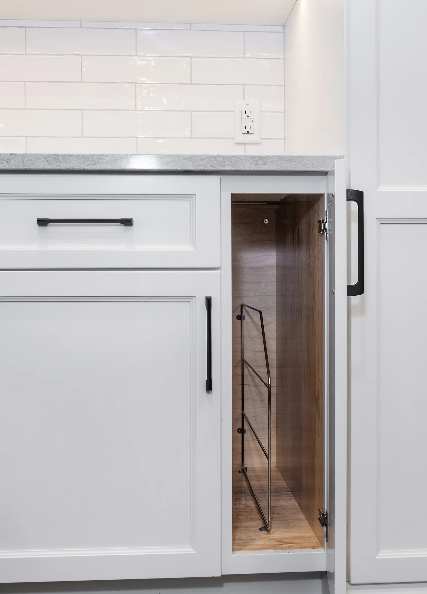 Vertical tray storage inside a white base cabinet