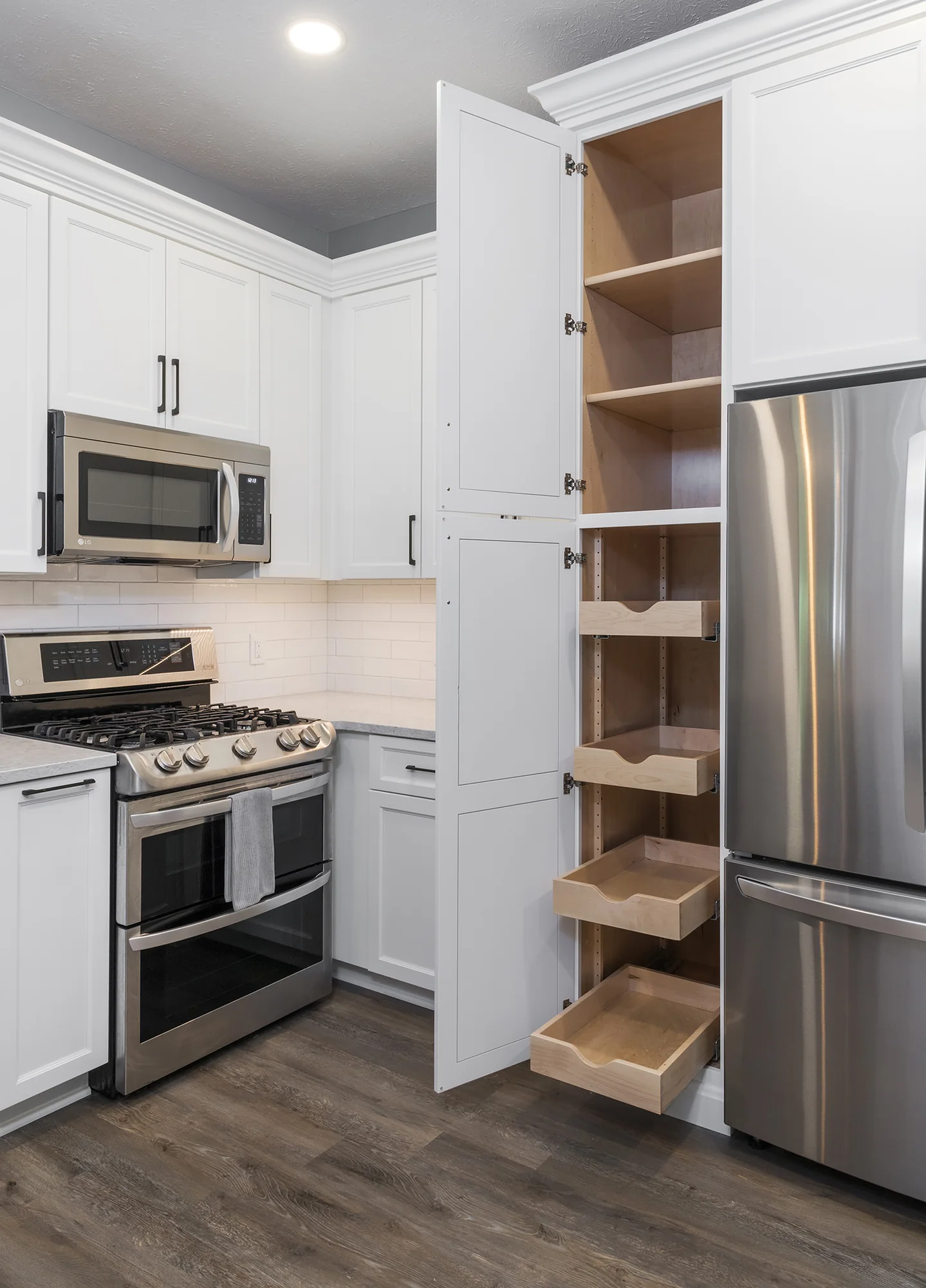 Tall pull-out pantry storage beside the refrigerator