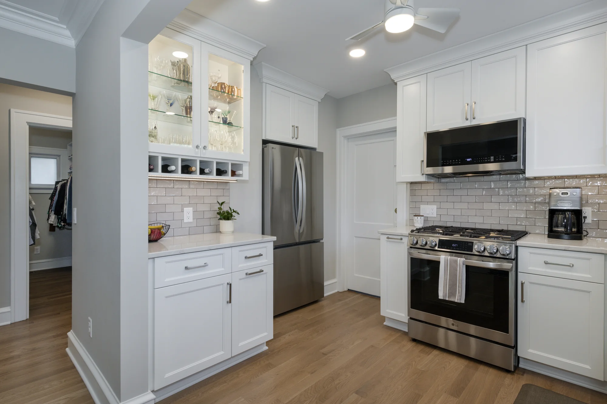 White kitchen cabinetry and glass-front display cabinet