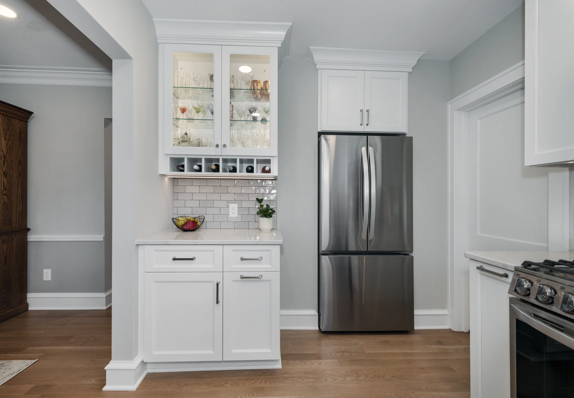 Glass-front display cabinet beside the refrigerator