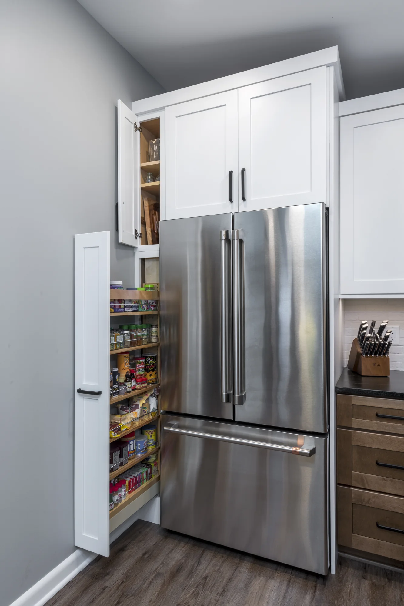 Tall pull-out pantry storage beside the refrigerator