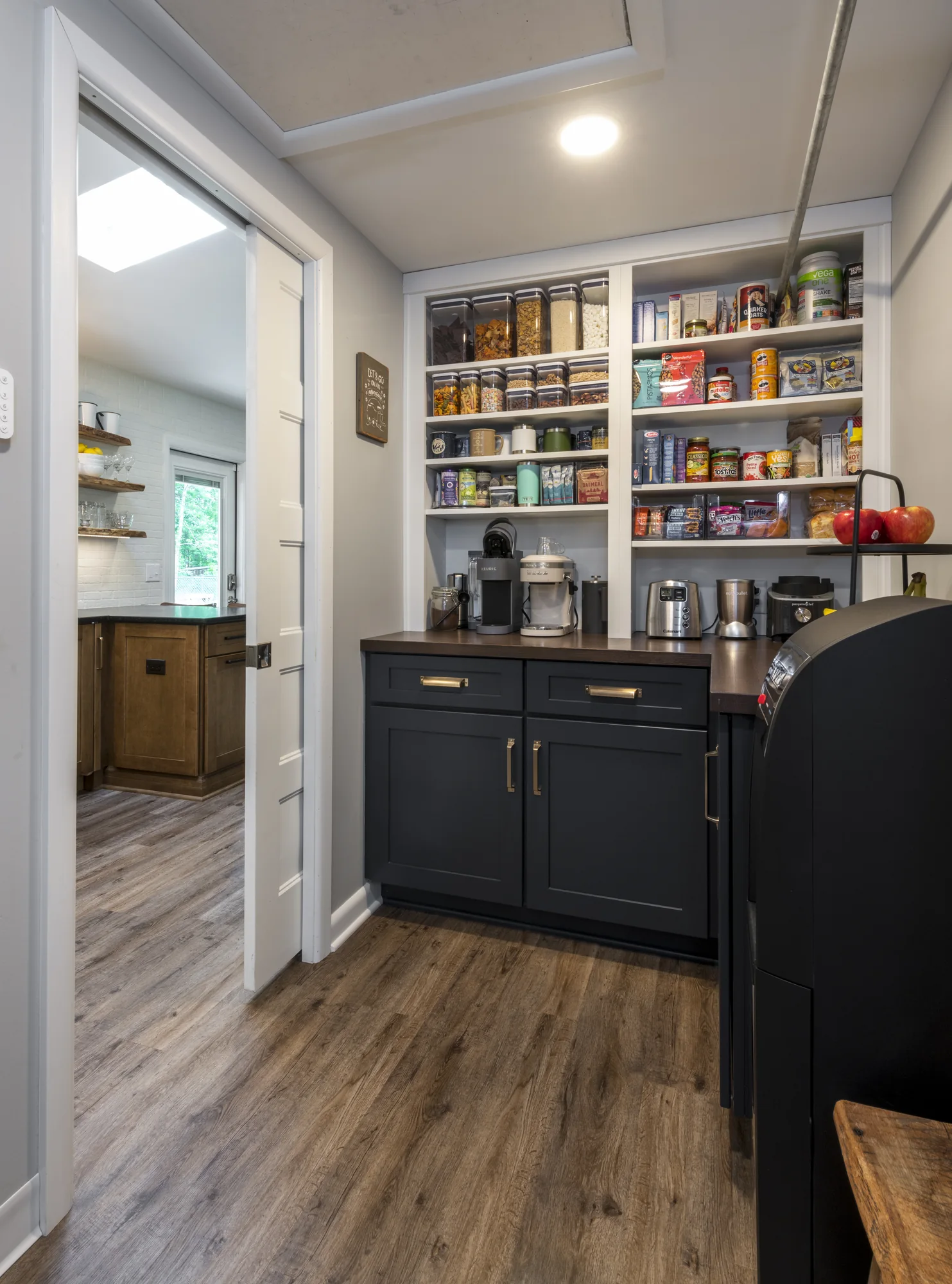 Custom pantry and beverage area with dark cabinetry