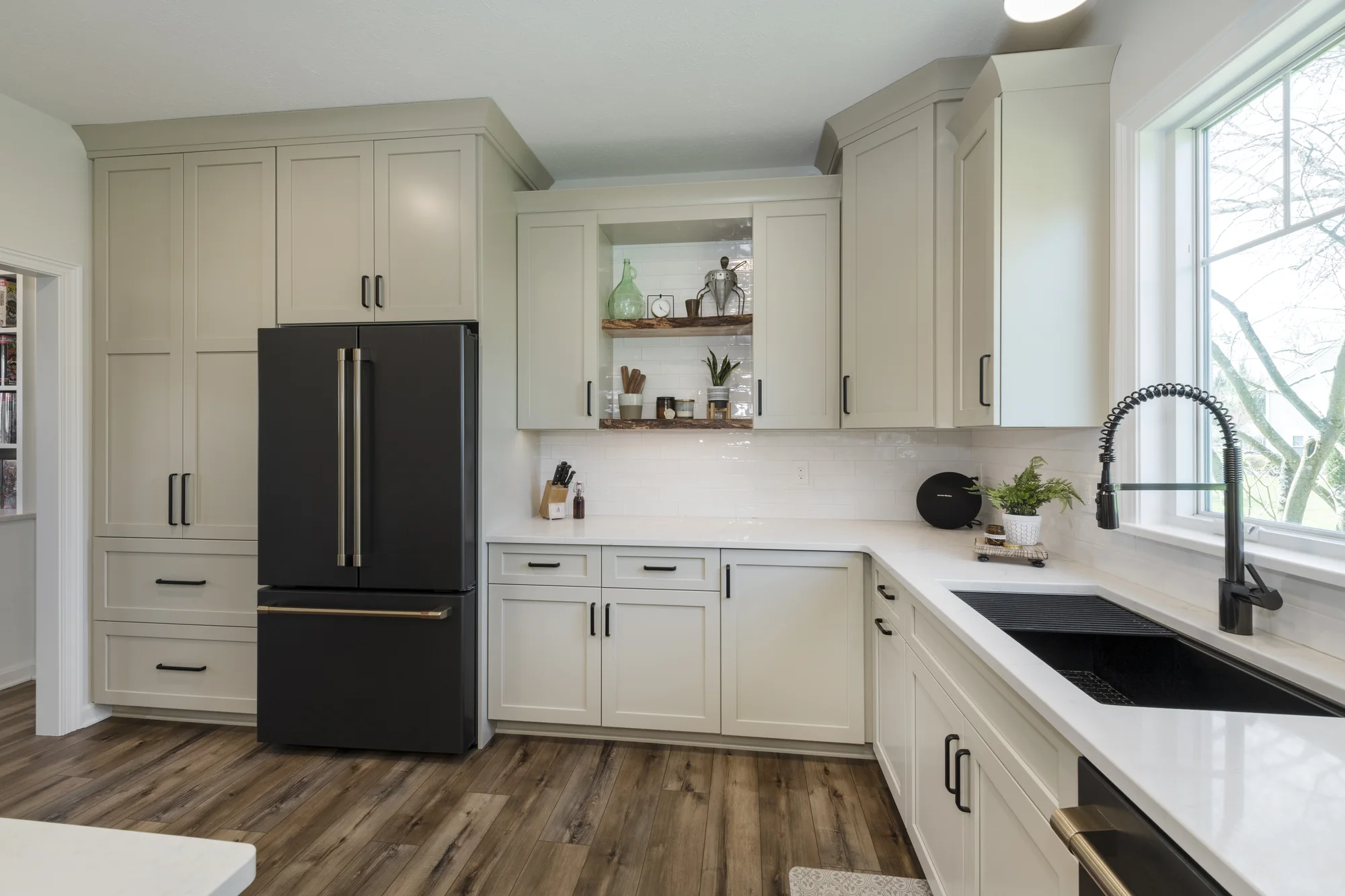 Warm cabinetry surrounding the refrigerator and sink